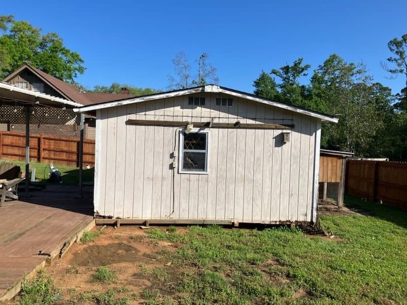 Before shed removal in a backyard with the structure still in place.