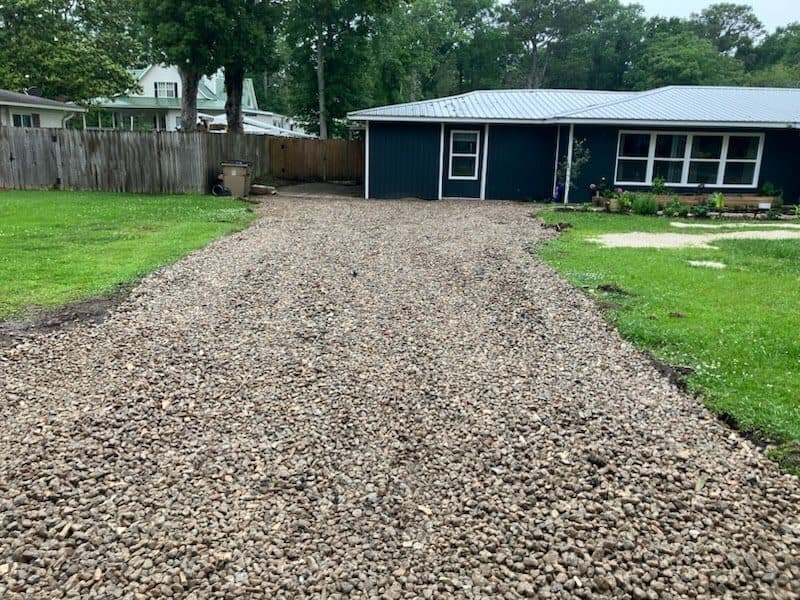 After the cracked driveway replacement with a fresh gravel finish.