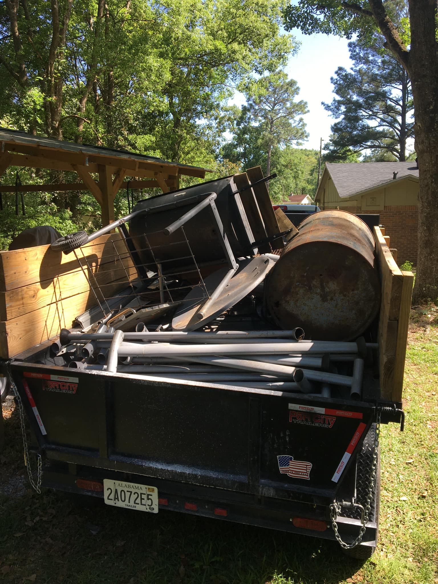 Trailer fully loaded with scrap metal, pipes, and junk removal debris on a Mobile, AL job