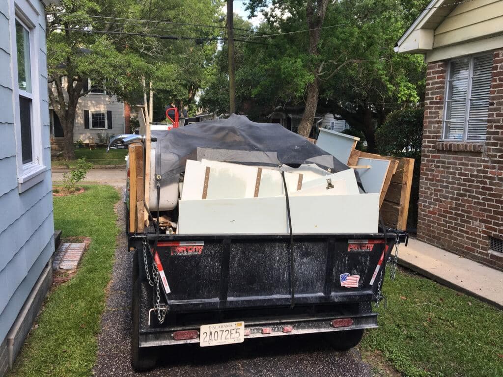 Trailer loaded with appliances and household junk at a residential cleanout in Mobile, AL