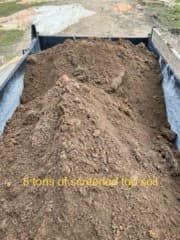 Screened top soil material in truck bed for yard leveling